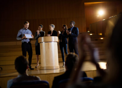 Male business executive receiving award at conference center